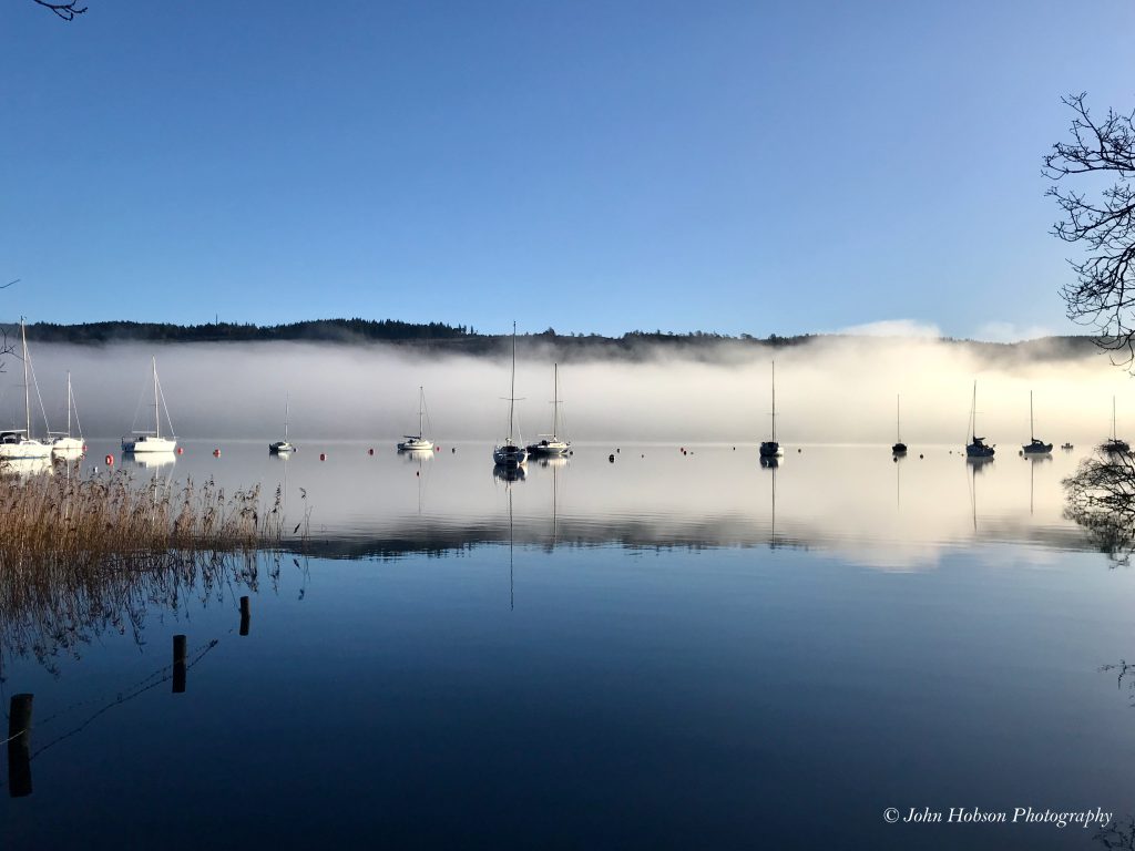 Coniston Water with boats in the mist